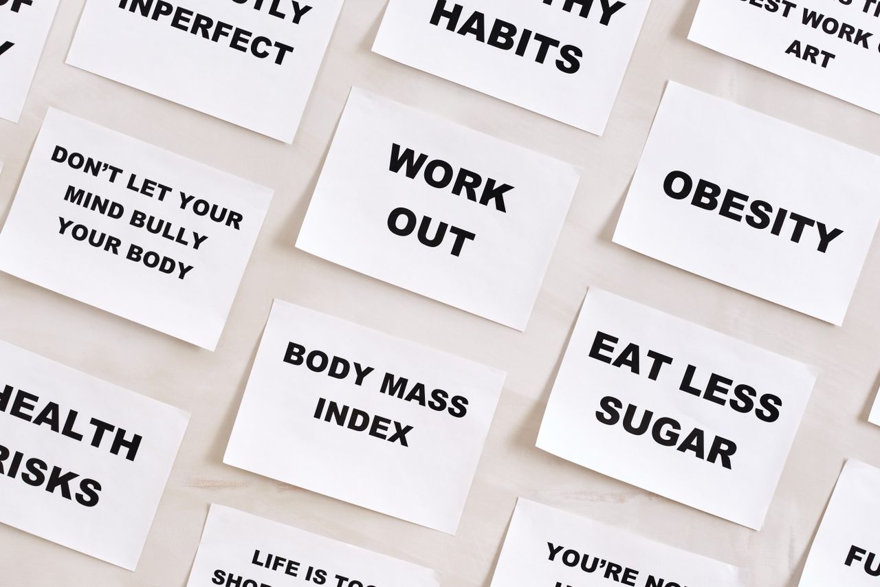Flat lay of motivational health quotes on paper, promoting healthy habits and self-care.